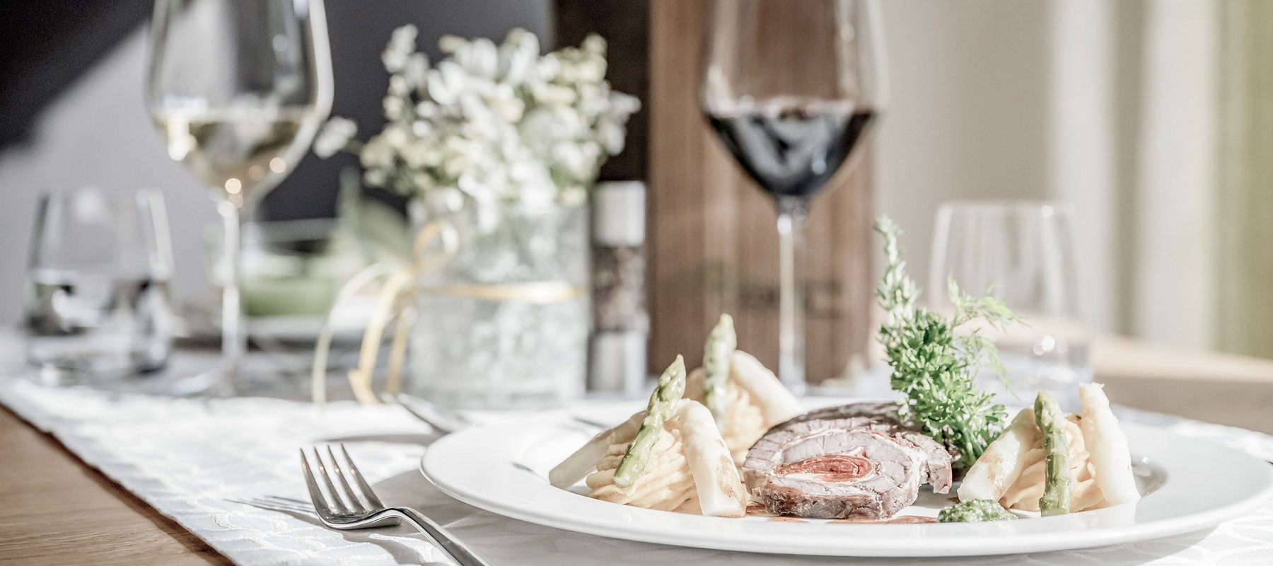 Braten mit Spargel und gefüllten Weingläsern