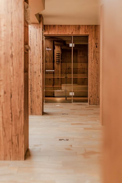 Flur im Wellnessbereich mit Zugang zu einer Sauna hinter Glas