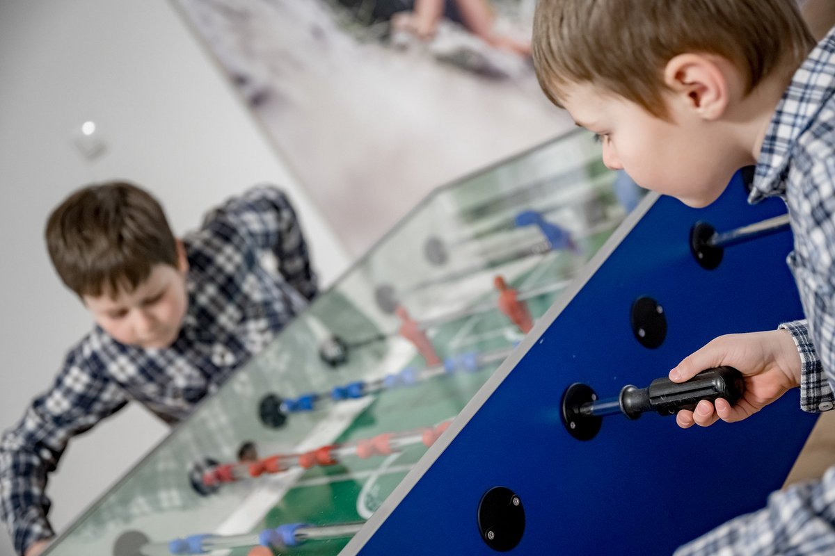 Kinder spielen gemeinsam Tischfußball