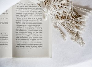 Geöffnetes Buch auf einem weißen Bettlaken